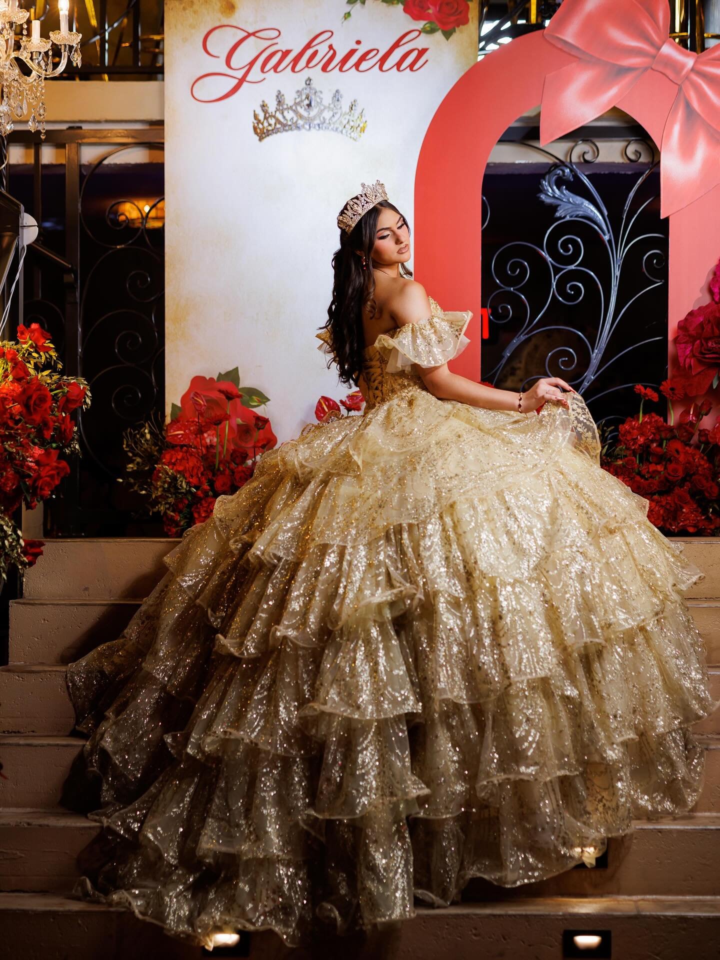 Quinceañera dorada en escaleras decoradas